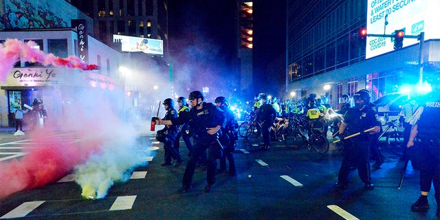 Smoke rises around police as they spray pepper spray during clashes with protesters after a May 31 demonstration over the death of George Floyd, an unarmed black man who died in Minneapolis Police custody, in Boston. A Boston-area man was federally charged Thursday with shooting at a group of police officers after a protest against police brutality.  (Photo by Joseph Prezioso / AFP) (Photo by JOSEPH PREZIOSO/AFP via Getty Images)