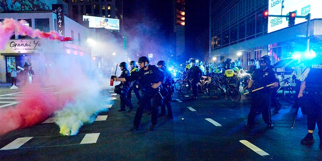 Smoke rises around police as they spray pepper spray during clashes with protesters after a May 31 demonstration over the death of George Floyd, an unarmed black man who died in Minneapolis Police custody, in Boston. A Boston-area man was federally charged Thursday with shooting at a group of police officers after a protest against police brutality.  (Photo by Joseph Prezioso / AFP) (Photo by JOSEPH PREZIOSO/AFP via Getty Images)