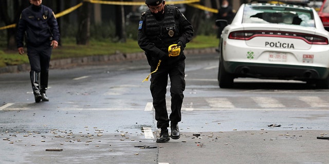 A police officer walks amid ammunition near the scene of a shooting in Mexico City, Mexico