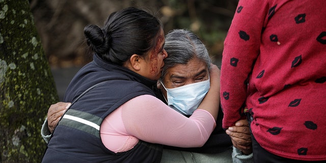The relatives of a woman killed during the assassination attempt of Mexico City's Chief of Police Omar Garcia Harfuch react near the crime scene on June 26.