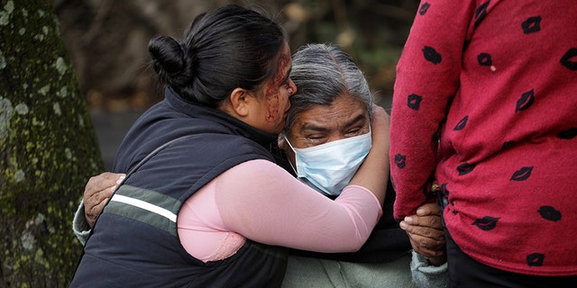 The relatives of a woman killed during the assassination attempt of Mexico City's Chief of Police Omar Garcia Harfuch react near the crime scene on June 26.
