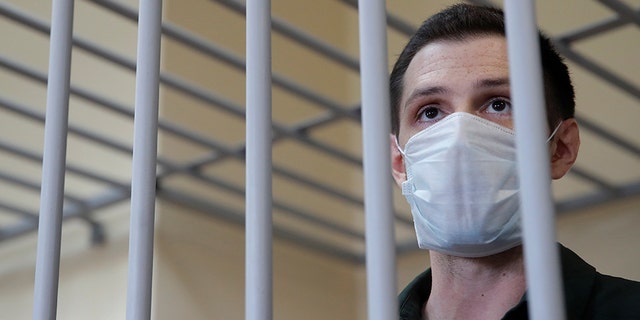 Former U.S. Marine Trevor Reed, who was detained in 2019 and accused of assaulting police officers, stands inside a defendants' cage during a court hearing in Moscow, Russia July 30. (Reuters/Maxim Shemetov)