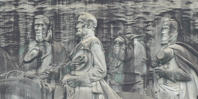 The carving depicts three Confederate figures, Jefferson Davis, Robert E. Lee, and Stonewall Jackson.