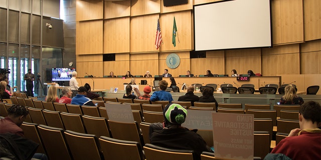 The Seattle City council conducts a meeting in its chambers. Several council members have seen offensive messages written outside their homes in response to their position on defunding the city's police department.