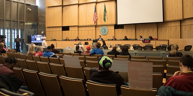 The Seattle City council conducts a meeting in its chambers. Several council members have seen offensive messages written outside their homes in response to their position on defunding the city's police department.