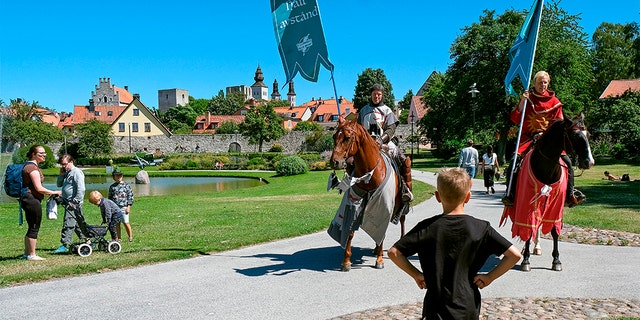 Thomas Lindgren (L) on the horse Soprano and Anders Mansson on Sara, both from the knight society Tornamenteum, patrol the city of Visby on the Swedish island of Gotland on July 23, 2020. (SOREN ANDERSSON/TT News Agency/AFP via Getty Images)