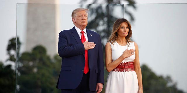 President Donald Trump and first lady Melania Trump place their hands on their chest during a "Salute to America" event on the South Lawn of the White House, Saturday, July 4, 2020, in Washington. 