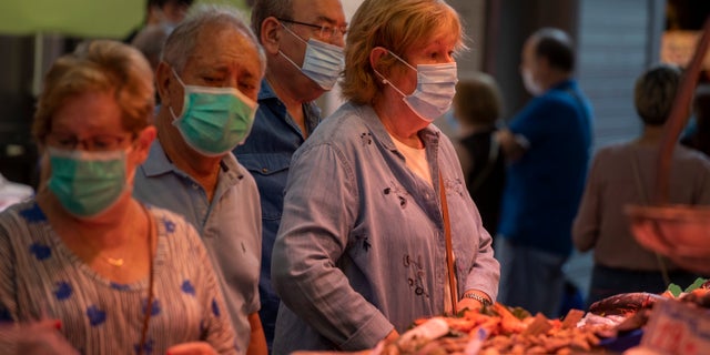 Customers buy fish at a market in Barcelona on Friday. Spanish health officials say many of the new coronavirus clusters that have popped up across the country are in the region of Catalonia. (AP)