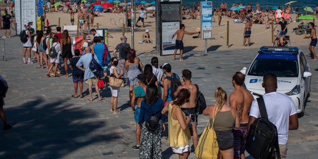 People wait to enter a beach that was closed by police due to crowding in Barcelona on Saturday. (AP)