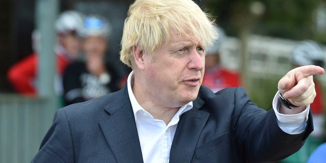 Britain's Prime Minister Boris Johnson, talks to cyclist Robert Cleave at the Canal Side Heritage Centre in Beeston near Nottingham, England on Tuesday. The government is launching a new cycling intuitive to help get people fitter. (AP Photo/Rui Vieira, Pool)
