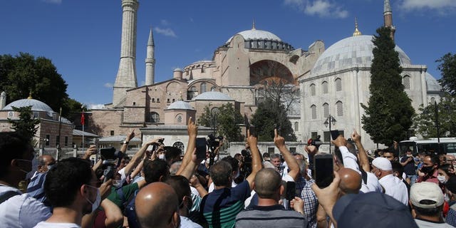 People chant slogans following Turkey's Council of State's decision, outside the Byzantine-era Hagia Sophia, one of Istanbul's main tourist attractions in the historic Sultanahmet district of Istanbul, Friday, July 10, 2020.