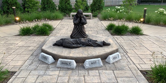 A statue in a Chicago neighborhood depicts Jesus grieving over the killing of an individual.