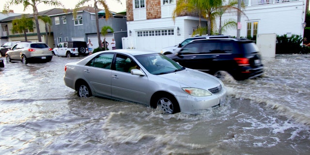 Vehicles drive through flooded streets in Newport Beach, Calif., July 3. The combination of surf and high tides could produce minor coastal flooding at the lowest coastal locations in the evenings during high tide this holiday weekend, according to the National Weather Service.