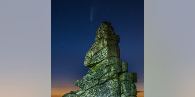 The Neowise comet over Stiperstones National Nature Reserve, Shropshire. See SWNS copy SWMDcomet: Breathtaking photographs show the Neowise comet streaking across the night sky above an ancient ridge in the Shropshire Hills. Andrew Fusek Peters spent hours waiting for the right conditions to capture the rare cosmic event over one of the oldest rock formations on the planet. He arrived at the at Stiperstones National Nature Reserve at dusk on Monday (20/7) but ended up taking the photos at closer to midnight.