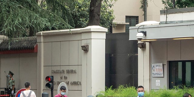 This photo taken on July 23, 2020 shows people walking past the entrance of the US consulate in Chengdu, southwest China's Sichuan province. China on July 24 ordered the closure of the U.S. consulate in the southwestern city of Chengdu, in retaliation for America shuttering Beijing's diplomatic mission in Houston this week.  (Photo by STR/AFP via Getty Images)