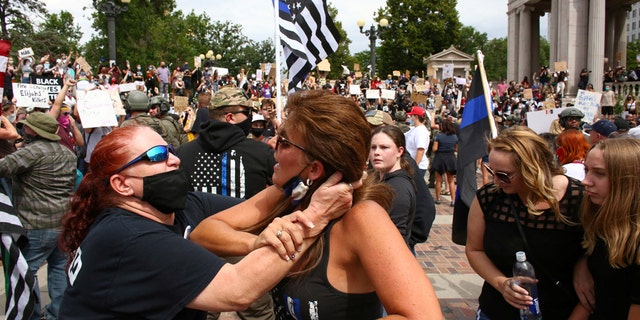 Two women begin to fight at a pro-law enforcement rally that clashed with counter-protesters demonstrating against racial inequality, in Denver, Colorado, U.S. on July 19, 2020. (Reuters/Kevin Mohatt)