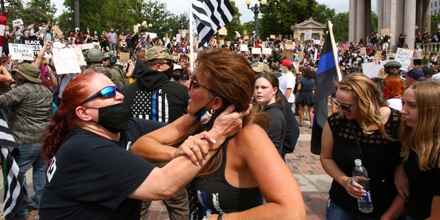 Two women begin to fight at a pro-law enforcement rally that clashed with counter-protesters demonstrating against racial inequality, in Denver, Colorado, U.S. on July 19, 2020. (Reuters/Kevin Mohatt)