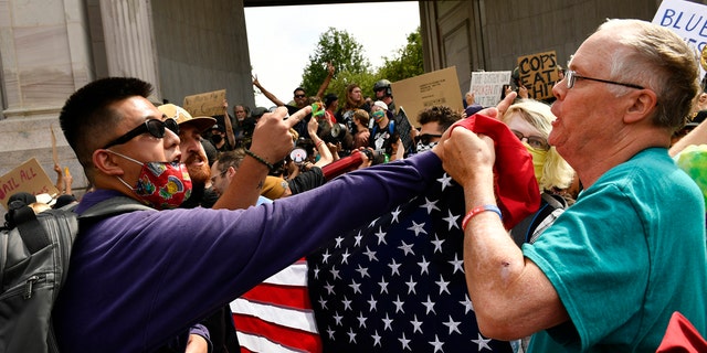 Anti-police protesters, left, clash with a Pro-Police Rally supporter when dueling rallies collided at Civic Center Park on July 19, 2020 in Denver, Colorado.  (Photo by Helen H. Richardson/MediaNews Group/The Denver Post via Getty Images)