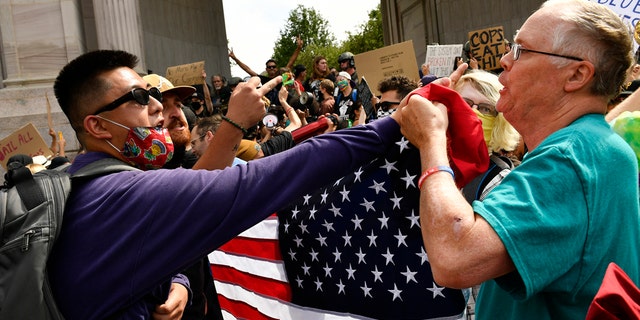 Anti-police protesters, left, clash with a Pro-Police Rally supporter when dueling rallies collided at Civic Center Park on July 19, 2020 in Denver, Colorado.  (Photo by Helen H. Richardson/MediaNews Group/The Denver Post via Getty Images)