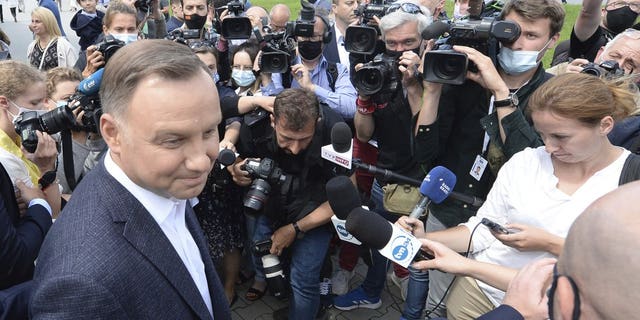 Candidate in Poland's tight presidential election runoff, incumbent President Andrzej Duda talks to reporters after having cast his ballot at a polling station in his hometown of Krakow, Poland, on Sunday, July 12, 2020. Conservative Duda is running against liberal Warsaw Mayor Rafal Trzaskowski and latest opinion polls suggest the race will be decided by a very narrow margin.