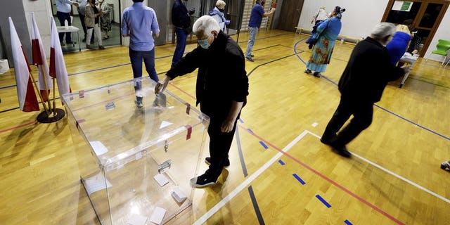 Voters cast their ballots shortly after polling stations open in Poland's tight presidential election runoff between conservative incumbent President Andrzej Duda and liberal Warsaw Mayor Rafal Trzaskowski, in Lomianki, near Warsaw, Poland, on Sunday, July 12, 2020. Latest polls showed that the race may be decided by a very small margin.