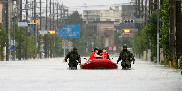 Japan Self Defense Force members rescue residents on a rubber boat on a flooded road hit by heavy rain in Omuta, Fukuoka prefecture, southern Japan Tuesday, July 7, 2020.