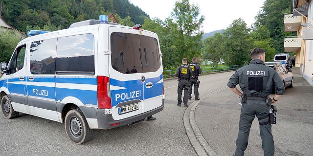 Police officers stand in front of a driveway in a forest area near Oppenau, Germany on Friday. (Benedikt Spether/dpa via AP)