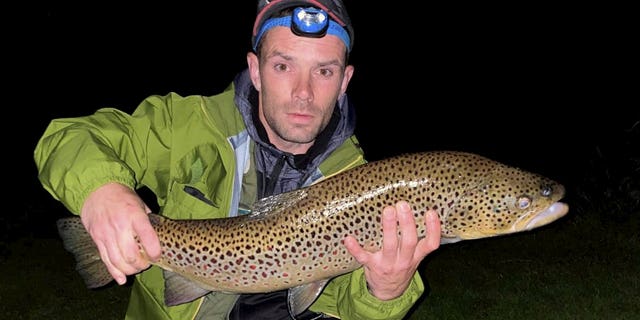 Barry Mcguigan poses with his massive wild brown trout on July 12. (SWNS)