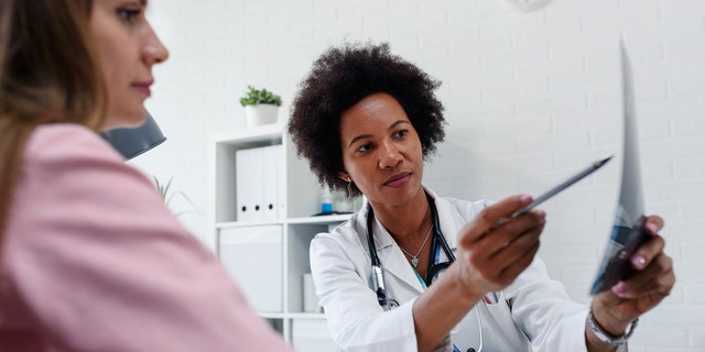 Doctor with a patient.  Some critics say some doctor positions have recently gone unfilled, in part because infectious disease fellowship programs have expanded too rapidly over the past few years.