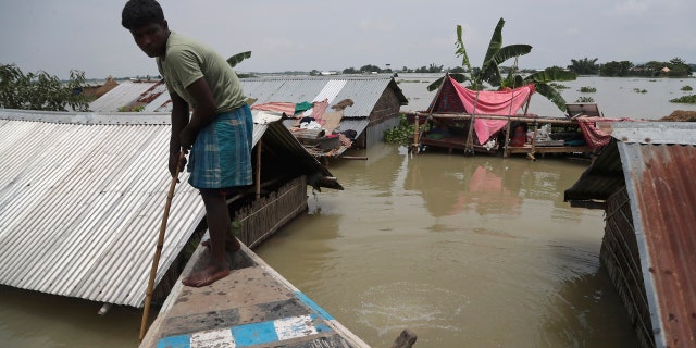 A man rows a boat near his submerged house in Gagolmari village, in Morigaon district of Assam, India, July 14.