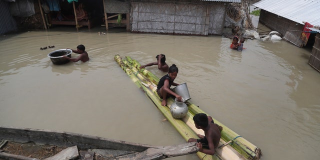 Flood affected villagers are seen near their partially submerged houses in Gagolmari village, Morigaon district, Assam, India, July 14.