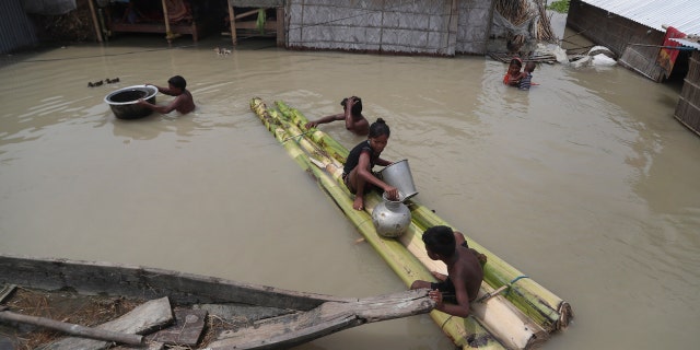 Flood affected villagers are seen near their partially submerged houses in Gagolmari village, Morigaon district, Assam, India, July 14.