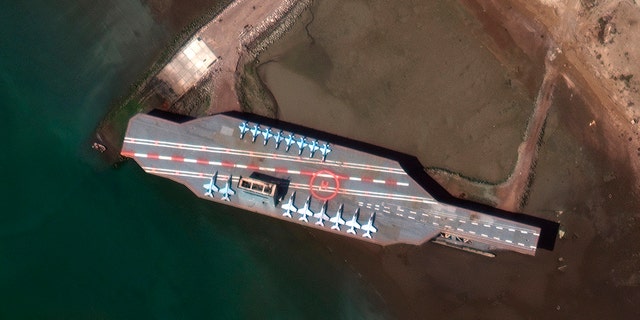 In this Feb. 15, 2020, satellite photo provided on July 27, 2020, by Maxar Technologies, a mockup aircraft carrier built by Iran is seen at Bandar Abbas, Iran, before being put to sea. Satellite photographs released Monday, July 27, showed Iran has moved the aircraft carrier out to sea likely for naval drills amid heightened tensions between Tehran and the U.S. (Maxar Technologies via AP)