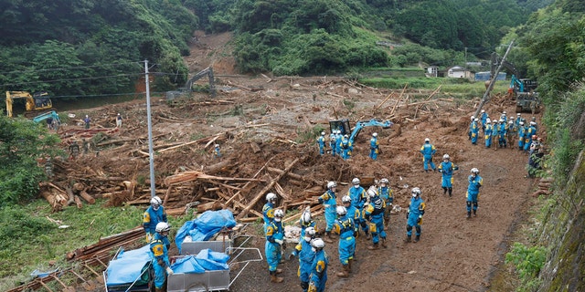 Rescuers search missing people at the site of a mudslide caused by heavy rain in Natsugi town, Kumamoto prefecture, southwestern Japan, Sunday, July 5, 2020.