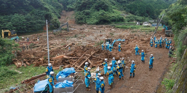 Rescuers search missing people at the site of a mudslide caused by heavy rain in Natsugi town, Kumamoto prefecture, southwestern Japan, Sunday, July 5, 2020.