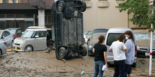 A car stands vertically on a muddy road after being washed away by flood, in Hitoyoshi, Kumamoto prefecture, southwestern Japan, Sunday, July 5, 2020.