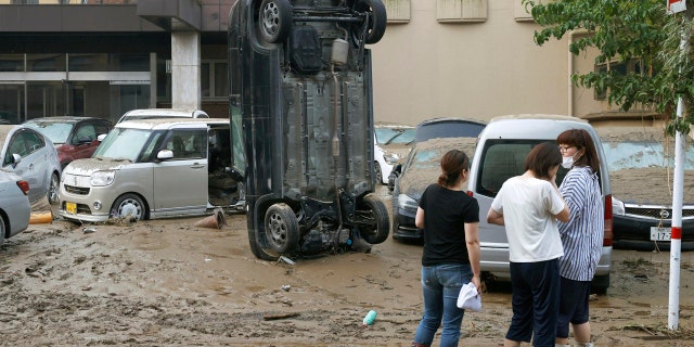 A car stands vertically on a muddy road after being washed away by flood, in Hitoyoshi, Kumamoto prefecture, southwestern Japan, Sunday, July 5, 2020.