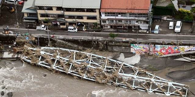 This aerial photo show a damaged bridge lies on the swollen Kusu River after heavy rains in Hita, Oita prefecture, southern Japan Wednesday, July 8, 2020.