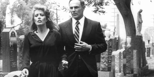 Ronee Blakley and John Saxon walking through a cemetery in a scene from the film 'A Nightmare On Elm Street,' 1984. (Photo by New Line Cinema/Getty Images)