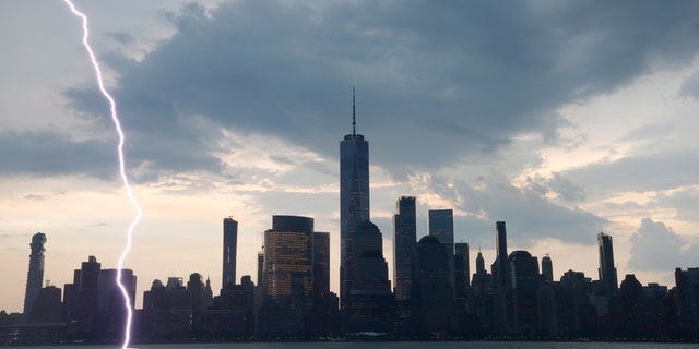 JERSEY CITY, NJ - JULY 22: A bolt of lightning hits the middle of the Hudson River in front of lower Manhattan and One World Trade Center during a thunderstorm in New York City on July 22, 2020 as seen from Jersey City, NJ. (Photo by Gary Hershorn/Getty Images)