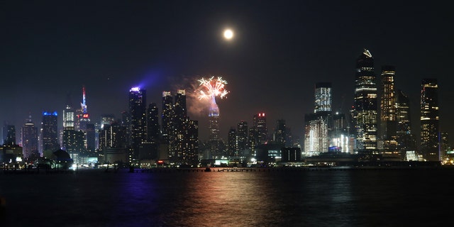 WEEHAWKEN, NJ - JULY 4: Macy's fireworks go off on the top of the Empire State Building as the full buck moon rises in the sky on July 4, 2020 as seen from Weehawken, New Jersey. (Photo by Gary Hershorn/FOX News)