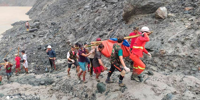 In this photo released from Myanmar Fire Service Department, rescuers carry a recovered body of a victim of a landslide from a jade mining area in Hpakant, Kachine state, northern Myanmar July 2.