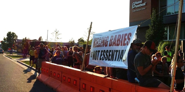 The Church at Planned Parenthood (TCAPP), gathers Tuesday, July 28, 2020 in front of a Planned Parenthood abortion clinic in Spokane, Wash.
