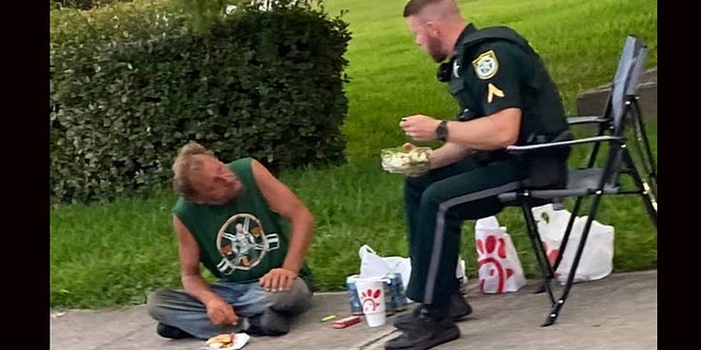 A photo of a Florida sheriff’s deputy and homeless man eating Chick-fil-A for lunch together has gone viral on Facebook.