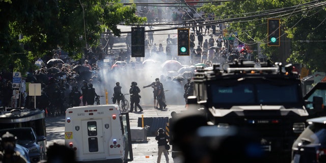 Smoke rises as police clash with protesters during a Black Lives Matter demonstration near the Seattle Police East Precinct headquarters on Saturday. (AP)