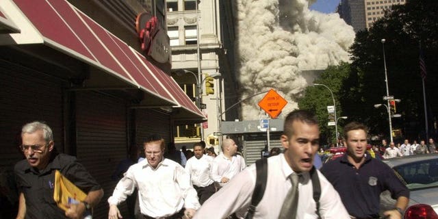 In this Sept. 11, 2001, file photo, people run from the collapse of one of the twin towers at the World Trade Center in New York. Stephen Cooper, far left, fleeing smoke and debris as the south tower crumbled just a block away on Sept. 11, has died from coronavirus, his family said, according to The Palm Beach Post.