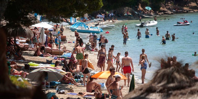 Sunbathers enjoy the beach in Pollença, in the Balearic Island of Mallorca, Spain on Tuesday. The U.K. government's recommendation against all but essential travel to the whole of Spain means that all travelers arriving in Britain from that country will have to undergo a 14-day quarantine. (AP Photo/Joan Mateu)