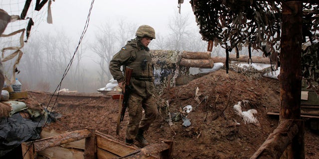 In this file photo dated Monday, Dec. 9 2019, a Ukrainian soldier takes position on the front line at the town of Novoluhanske in the Donetsk region, Ukraine.