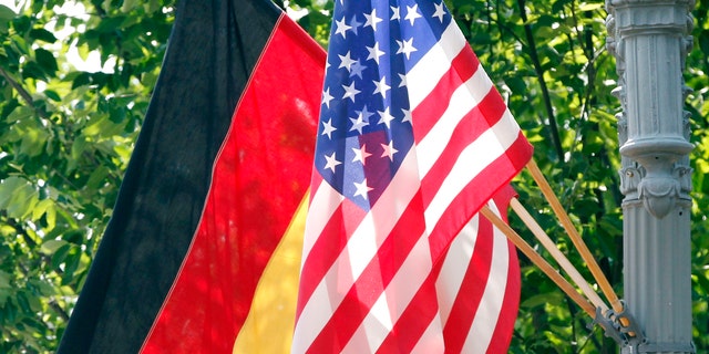 In this 2011 file photo, the German and U.S. flags fly on a lamp post in front of the White House in Washington ahead of German Chancellor Angela Merkel's visit. Defense officials say the U.S. will pull 12,000 troops from Germany, bringing 6,400 forces home and shifting 5,600 to other countries in Europe, including Italy and Belgium. The plan will cost billions of dollars and take years to complete. (AP)