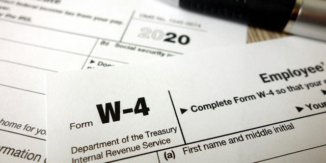 Blank W-4 form and a pen. Tax season